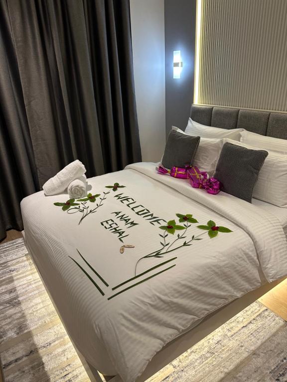 a bed with a white blanket with flowers on it at Aira Residence - 2nd Floor 1007 in Hulhumale
