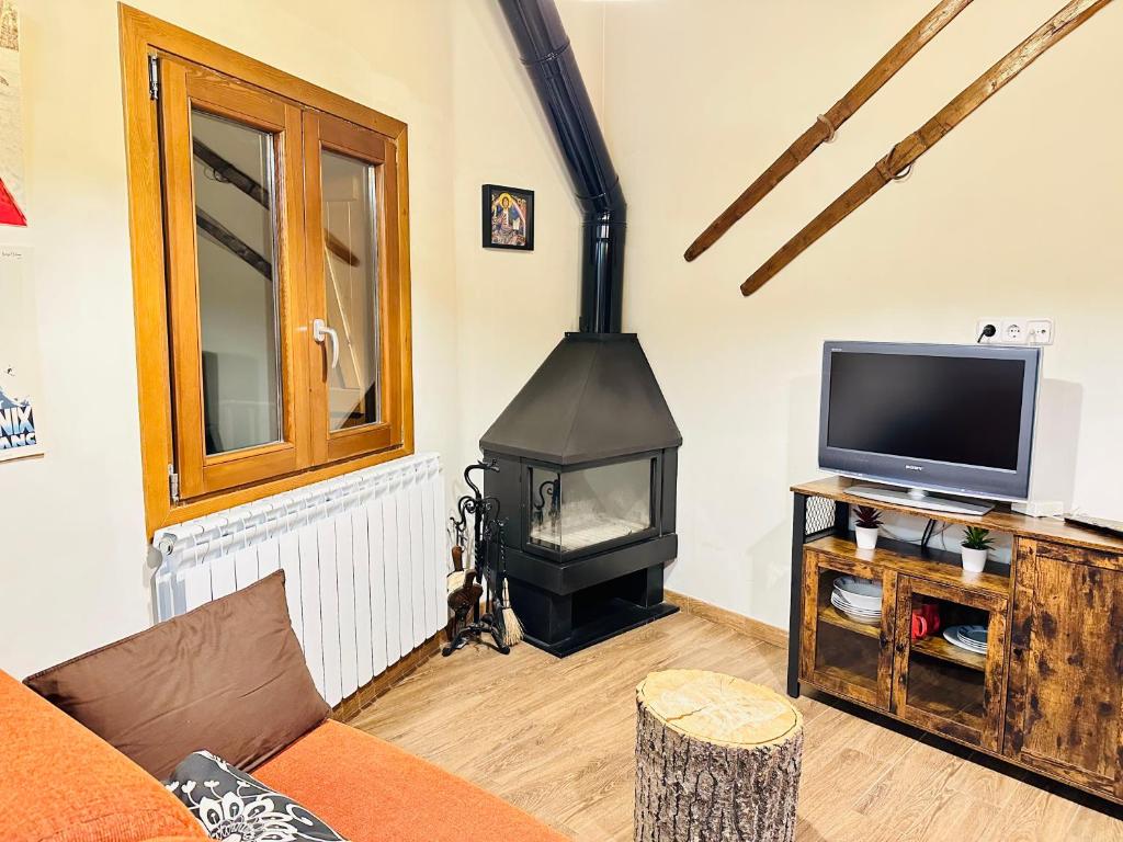 a living room with a wood stove and a tv at Apartament Immovall in Durro