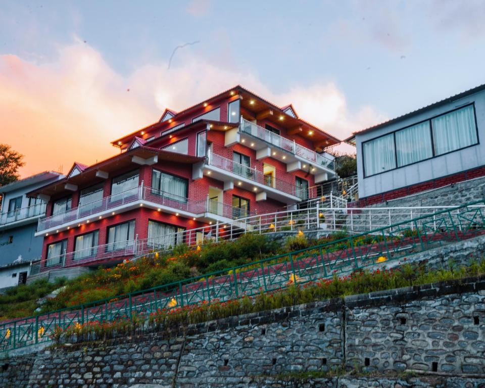 a red building on top of a hill at Aaryam Resort, Auli in Joshīmath