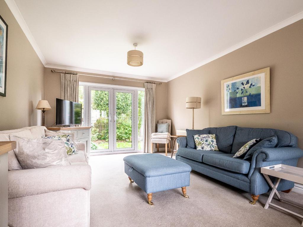 sala de estar con sofá azul y TV en Pass the Keys Bright, comfortable 3 bed home with garden & parking, en Ottery St Mary