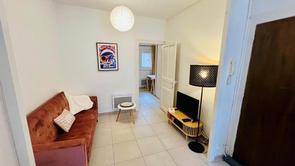 un salon avec un canapé et une télévision dans l'établissement T2 Sète proche centre ville, à Sète