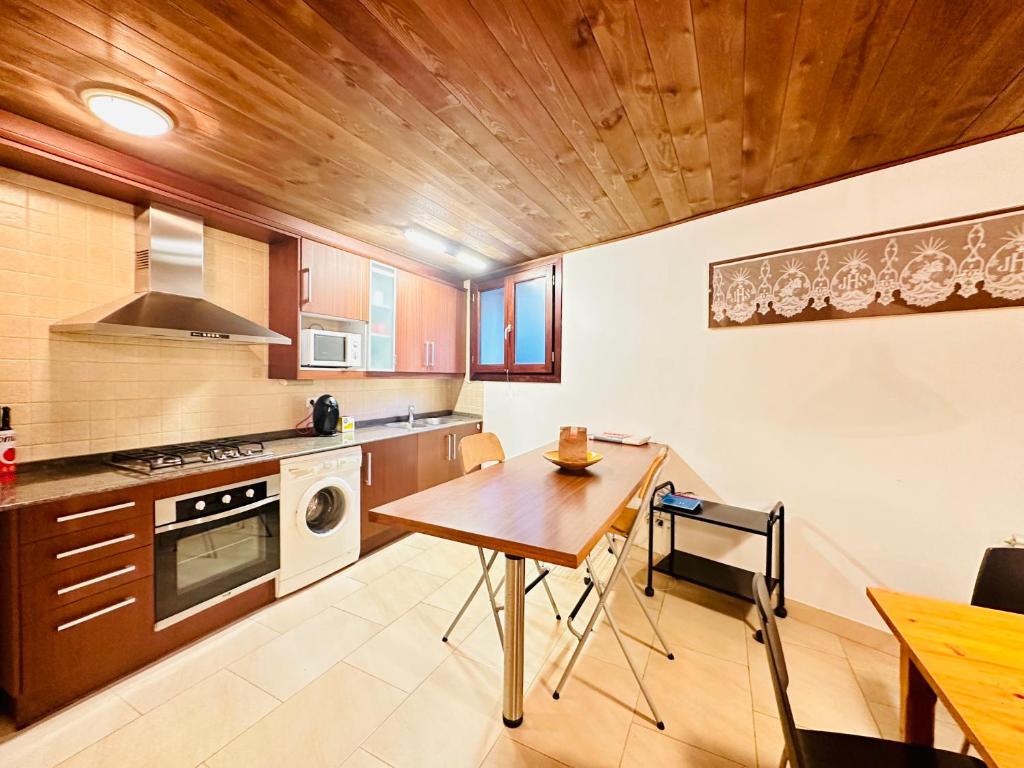 eine Küche mit einem Tisch und einer Holzdecke in der Unterkunft BA12 IMMOVALL BARRUERA in Barruera
