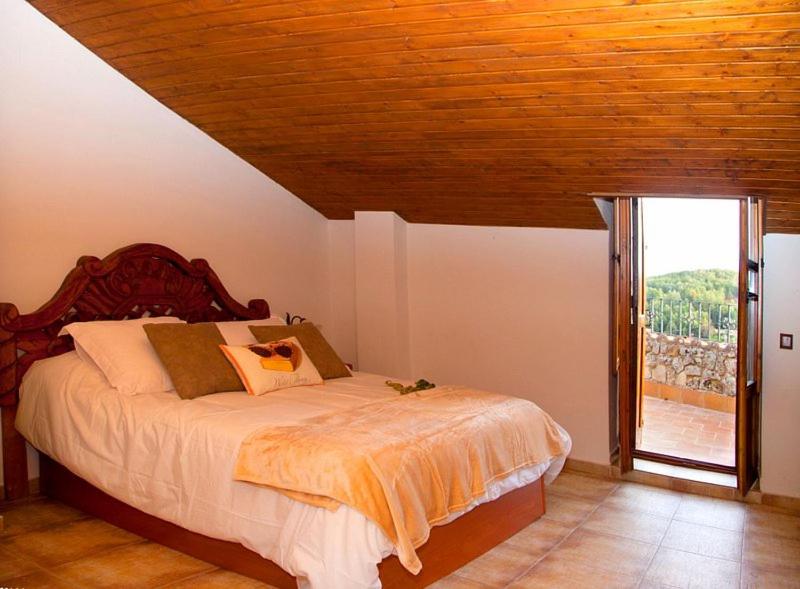 Schlafzimmer mit einem Bett mit Holzdecke in der Unterkunft Alojamiento Rural Villanueva del Conde in Villanueva del Conde