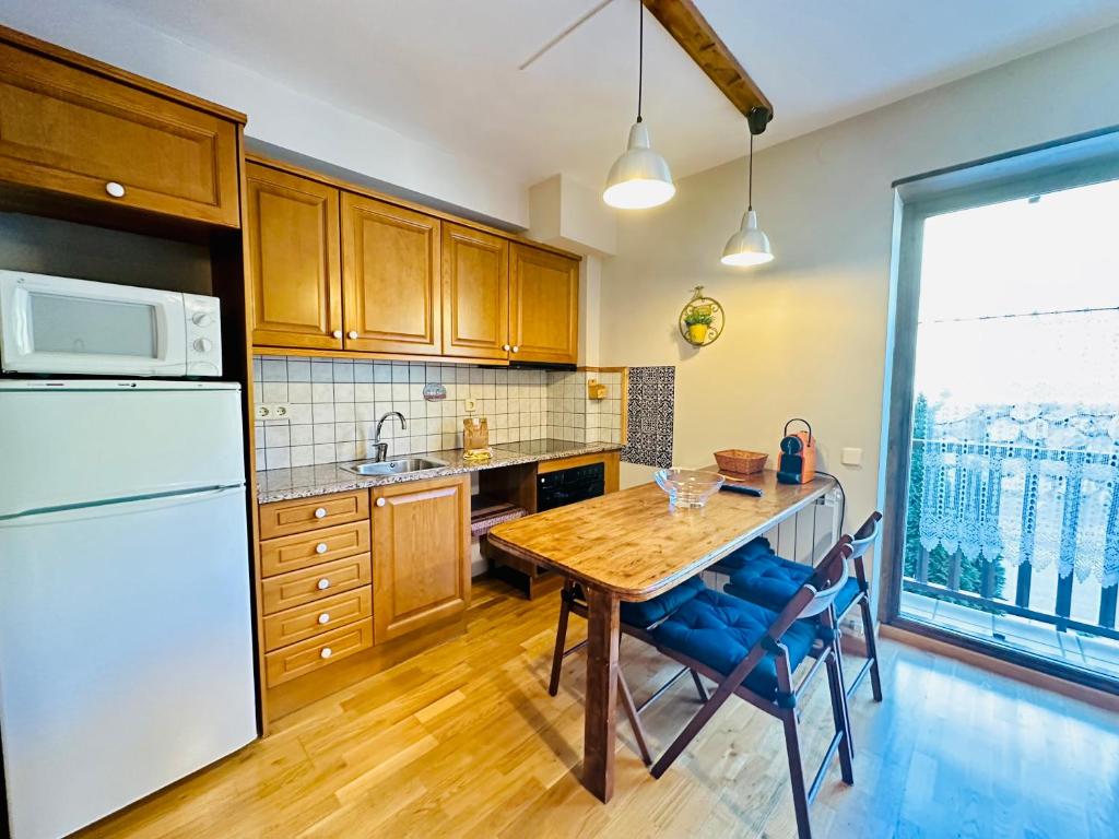 cocina con mesa de madera y nevera blanca en Estudio C/Montanya, en Pla de l'Ermita