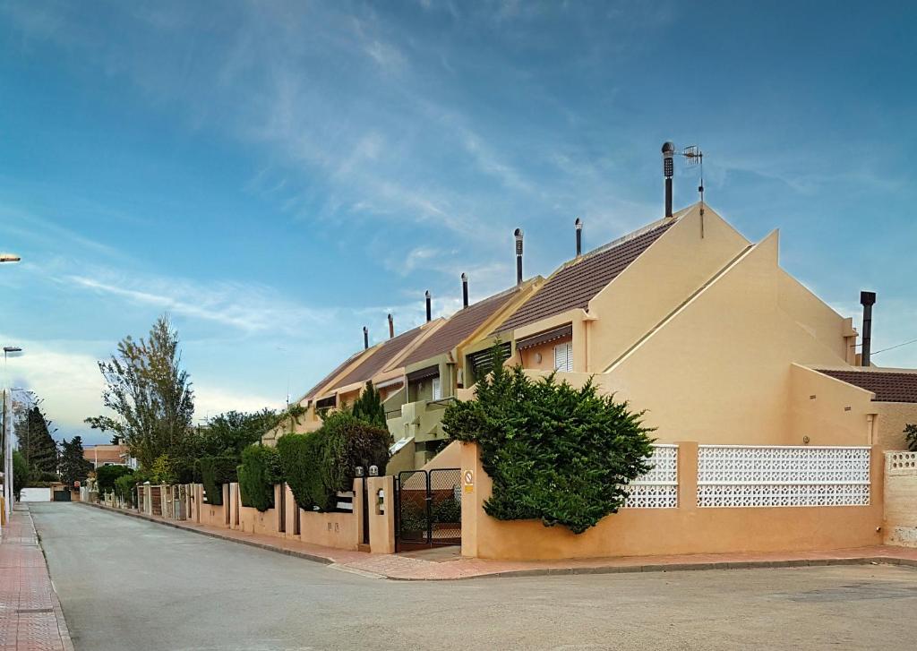 um edifício com uma cerca ao lado de uma rua em La casa de la Bahía em Puerto de Mazarrón