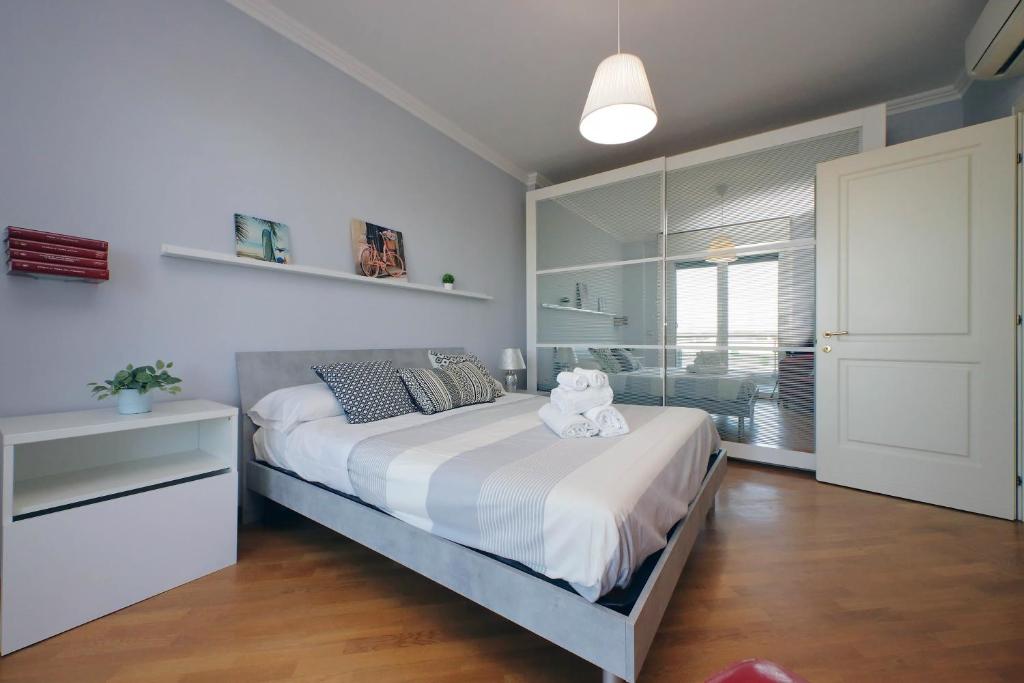 una camera da letto con un grande letto con lenzuola bianche e una finestra di Bilocale con vista sull'aeroporto - comodo per il viaggio a Fiumicino