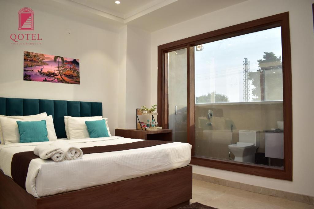 a bedroom with a large bed and a bathroom at Qotel Hotel Ashok Vihar Couple Friendly in New Delhi