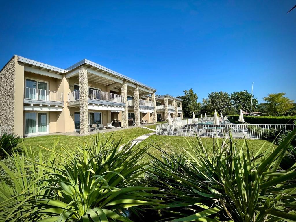 um grande edifício com um quintal com plantas em La Giolosa Gardapartments em Moniga