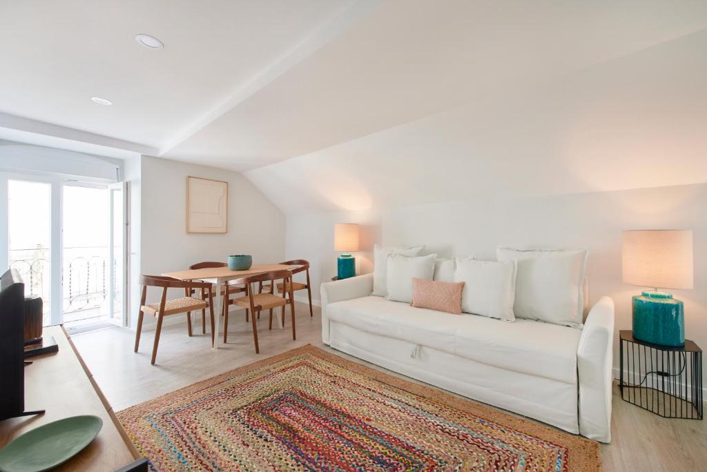 uma sala de estar com um sofá branco e uma mesa em Renovated House Near Beaches, By TimeCooler em Setúbal