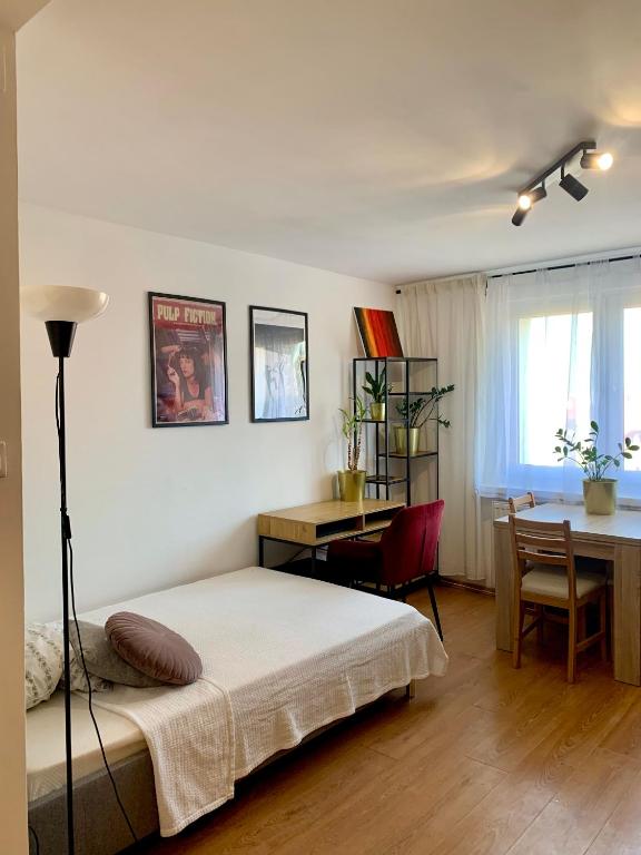 a bedroom with a bed and a desk and a table at Apartament Oliwa in Gdańsk