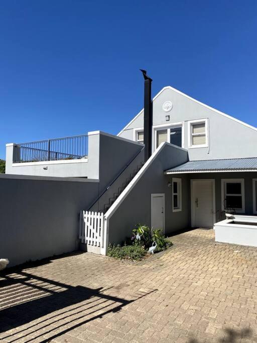 a white house with a staircase in front of it at Myrtle Loft in Cape Town