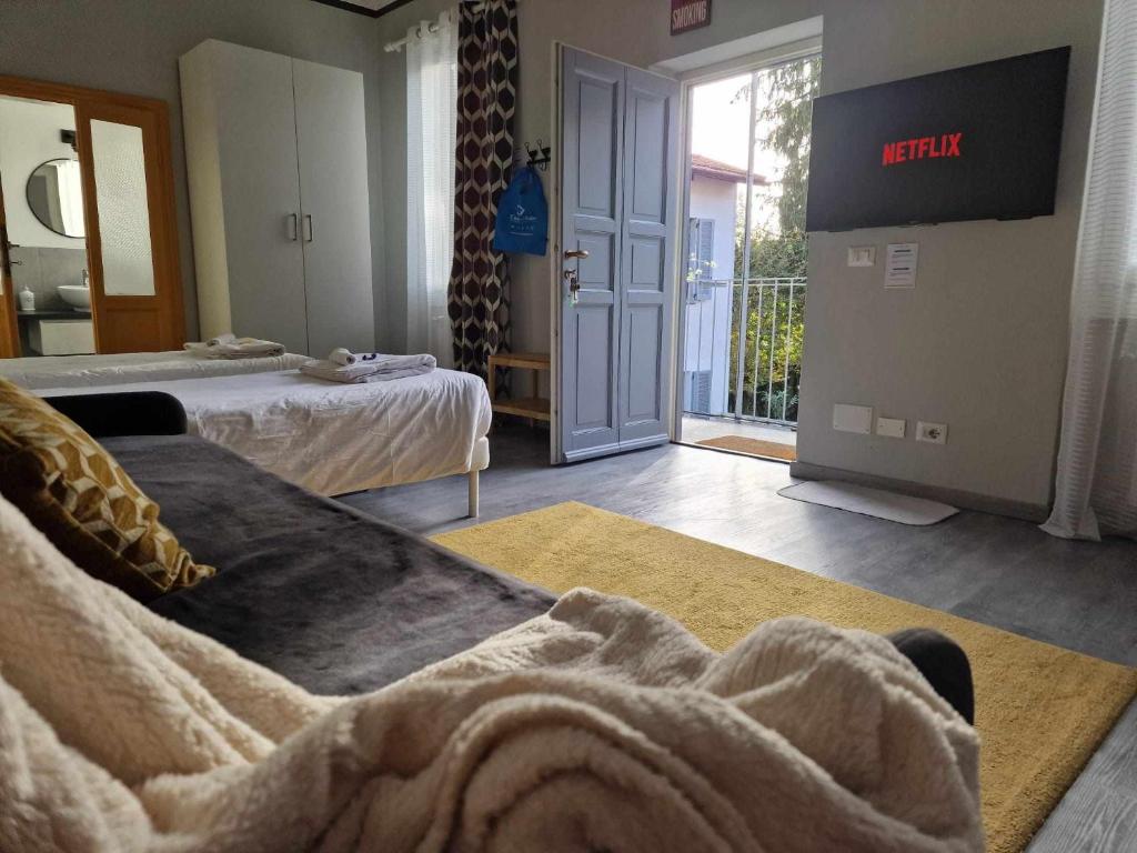 1 Schlafzimmer mit 2 Betten und Blick auf einen Balkon in der Unterkunft Corte del Fuin - Dreaming Italy Travel in Seregno