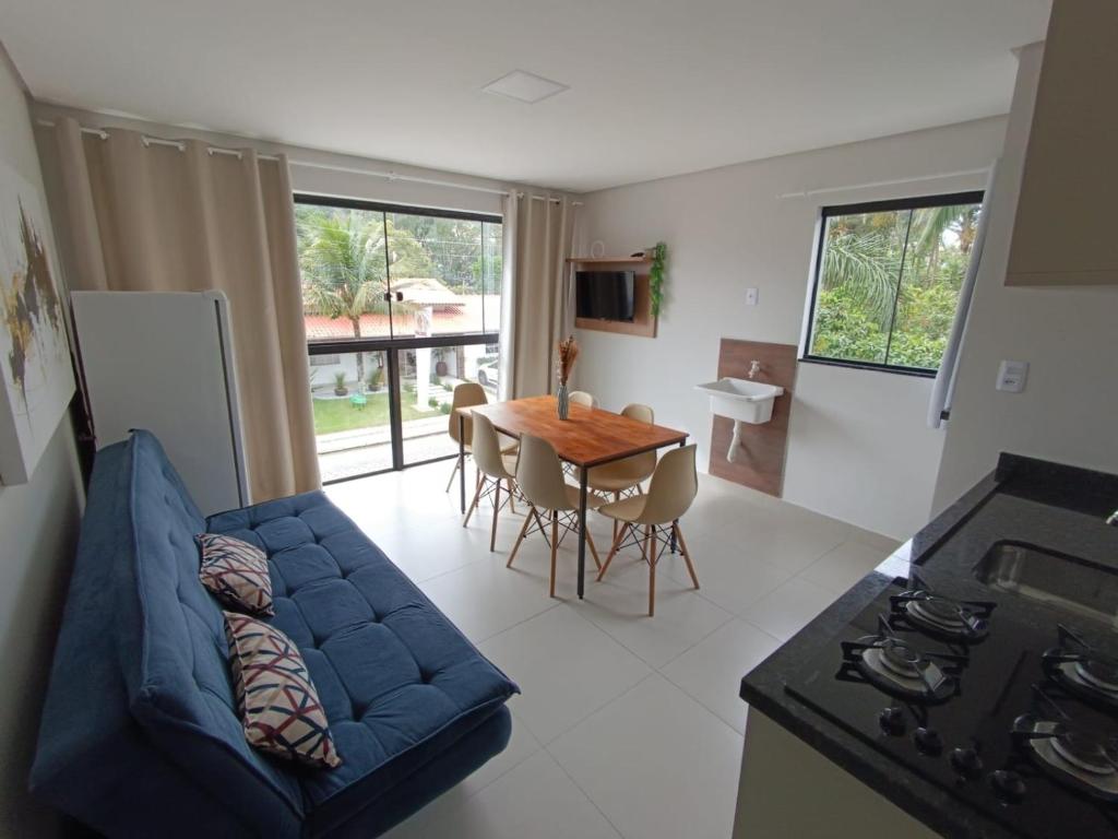 uma sala de estar com um sofá azul e uma mesa em Residencial Brisa do Mar em Bombinhas