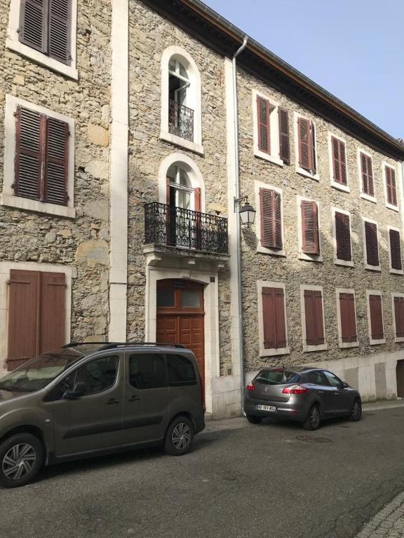 deux voitures garées devant un immeuble dans l'établissement La Cascade appartement F2, à Eaux-Bonnes