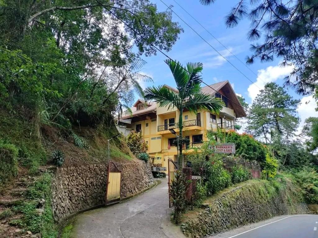 una casa amarilla al lado de una colina en Trekkers Lodge and Cafe, en Banaue