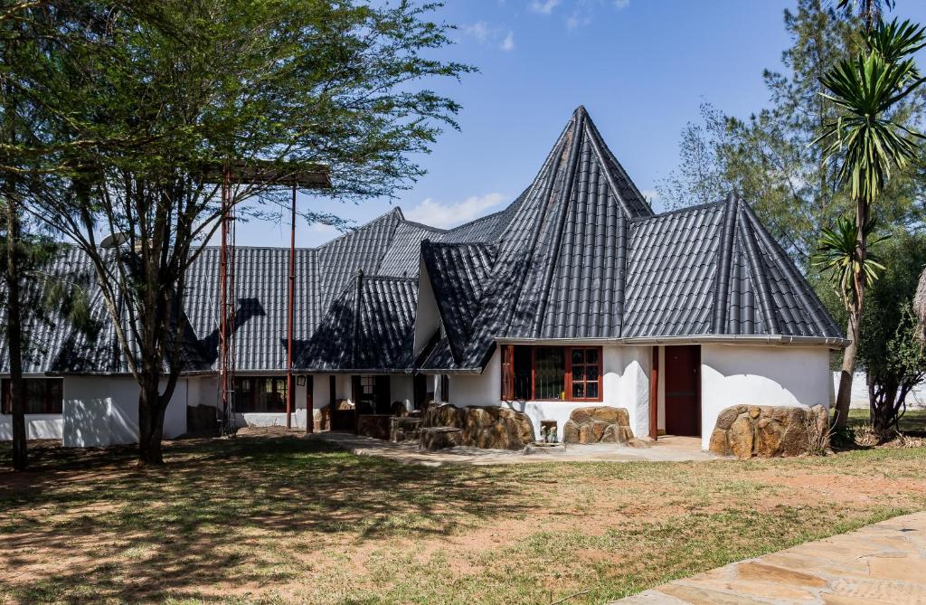 a house with a black roof at Maanzoni - Ndoto House ,Athi River by Nest & Nomad in Machakos