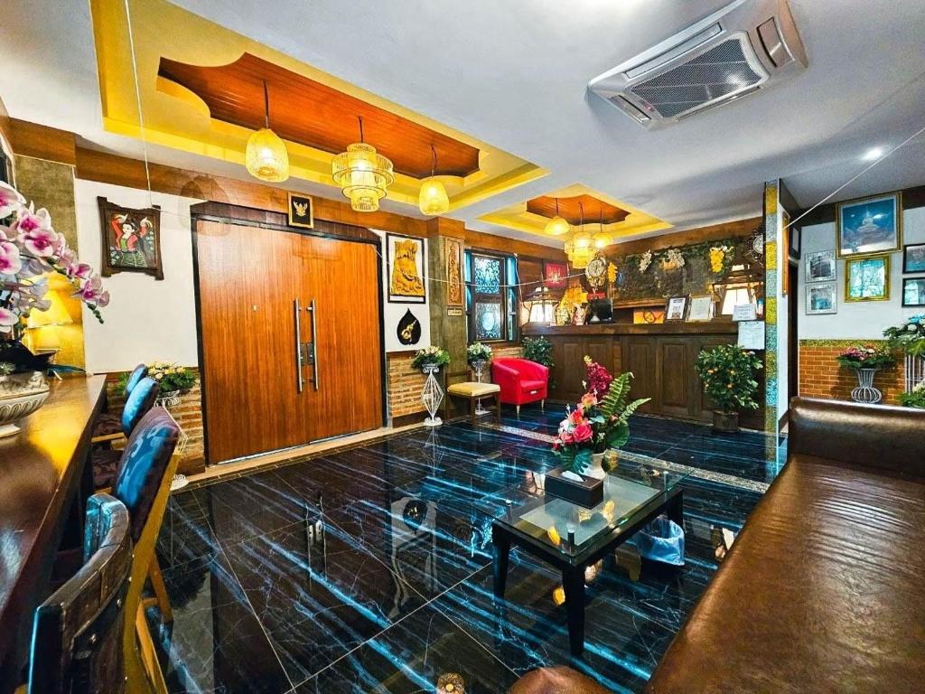 โรงแรมเชียงใหม่ล้านนา & โมเดิร์นลอฟท์ (Chiangmai Lanna Modern Loft Hotel) في سان كامبينغْ: غرفة معيشة مع أريكة وطاولة