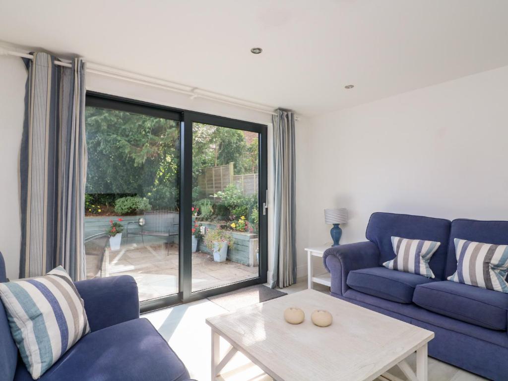 ein Wohnzimmer mit einem blauen Sofa und einem Tisch in der Unterkunft 1 Camperdown Lodge in Salcombe