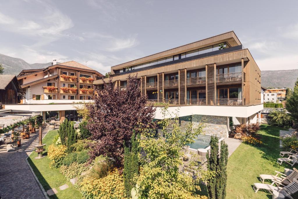 ein Apartmenthaus mit einem Garten davor in der Unterkunft Hotel Restaurant Langgenhof in Bruneck