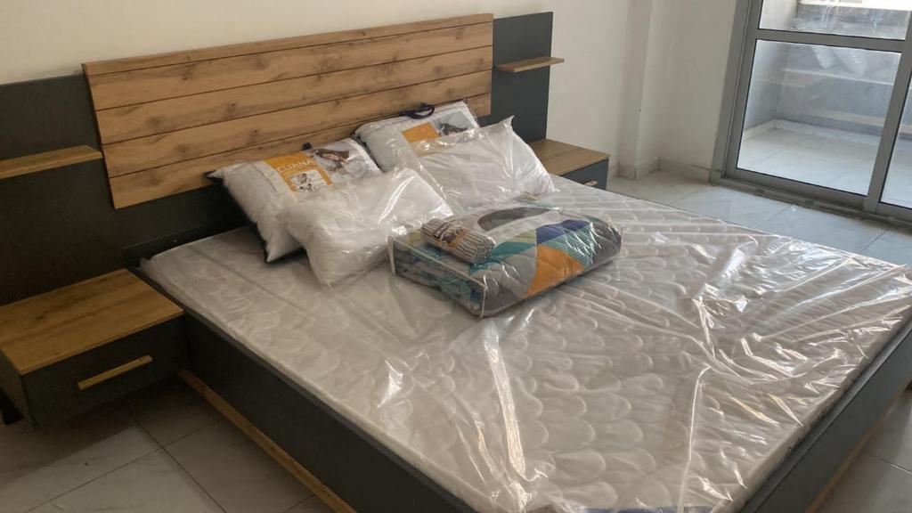 een groot bed bedekt met plastic in een kamer bij Abu Dhabi Tourist Club-Hotel Home Stay in Abu Dhabi