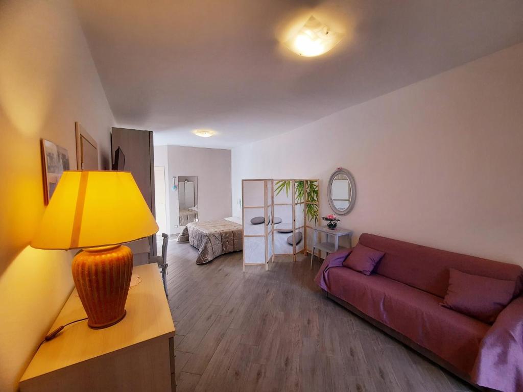 un soggiorno con divano rosso e lampada gialla di B&B Solimo a Sulmona