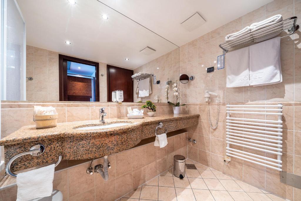 a bathroom with a sink and a large mirror at Hotel Princess in Bar