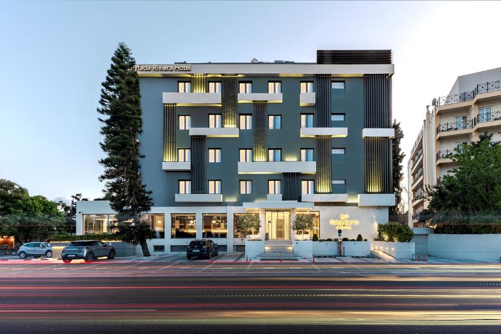 アテネにあるGlyfada Riviera Hotelの正面に駐車場がある建物