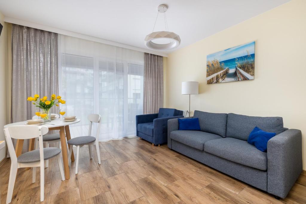 a living room with a couch and a table at Modern Studio in Resort & SPA Dziwnów by Renters in Dziwnów