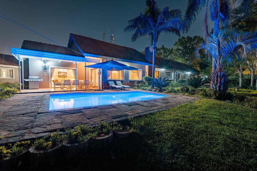 a house with a swimming pool at night at Royal Ridge Guesthouse in Pretoria