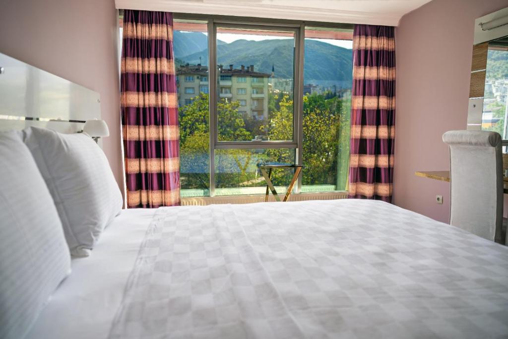 a bedroom with a bed and a large window at TOK EPİK HOTEL in Bursa