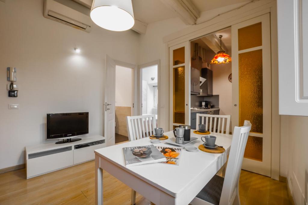 a white dining room with a white table and chairs at Spada Apartment in Florence