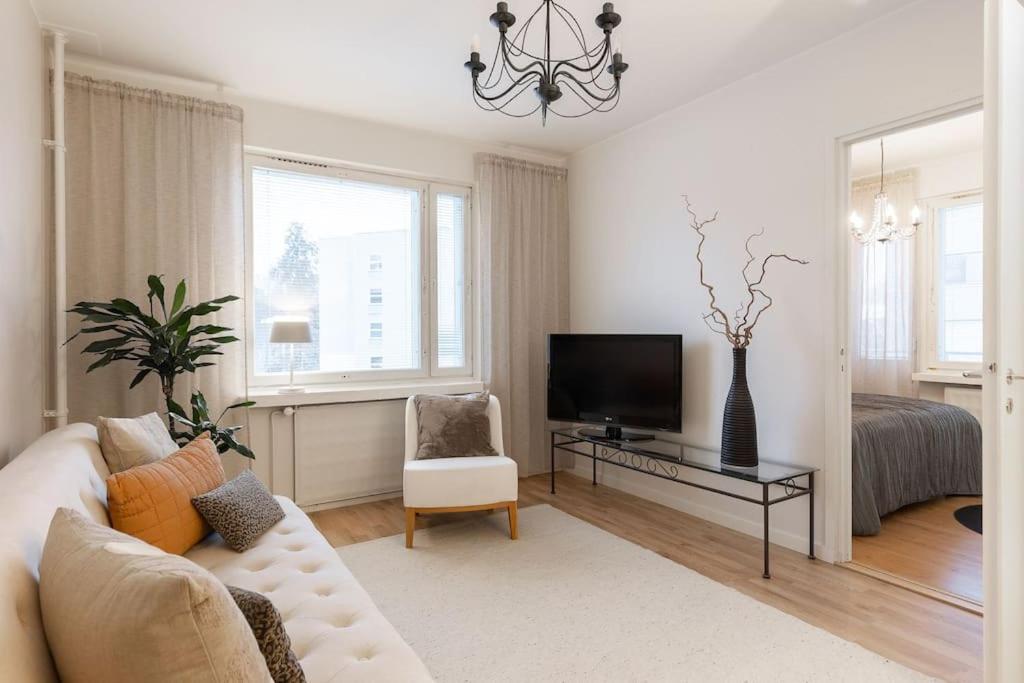 a living room with a couch and a television at Tunnelmallinen kaksio in Jyväskylä