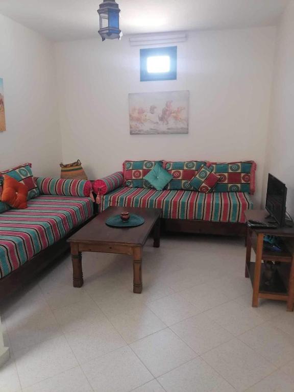 uma sala de estar com dois sofás e uma mesa de centro em app à Tamraght prés de la plage de 100m em Agadir