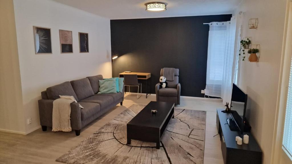 a living room with a couch and a table at Stylish apartment in town centre in Sotkamo