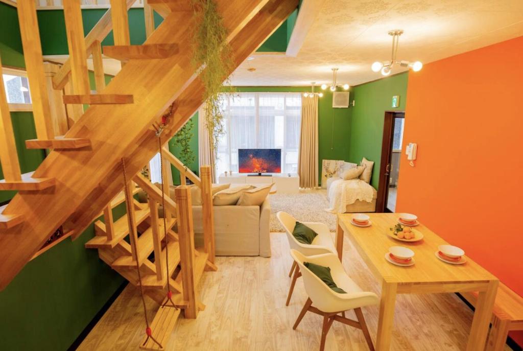 a living room with a wooden staircase and a living room at Yuzawa Onsen Lodge 1min to LIFT House in Seki