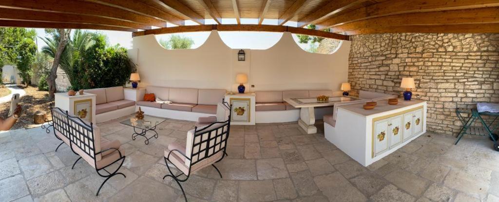 a patio with chairs and a table and a couch at Villa Anna Buonvino in Giovinazzo