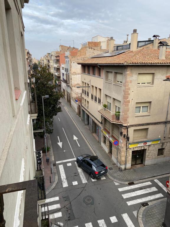 un coche conduciendo por una calle de la ciudad con edificios en Apartamento en el centro, en Igualada