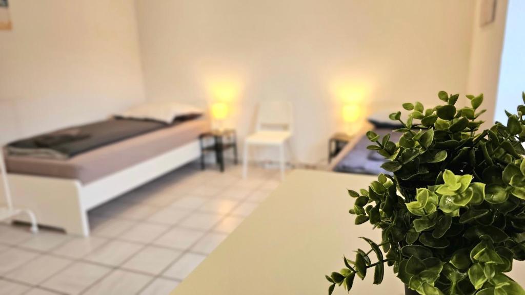 Un dormitorio con una cama y una mesa con una planta en 1 room apartment with 3 beds and terrace (ALT03), en Altena
