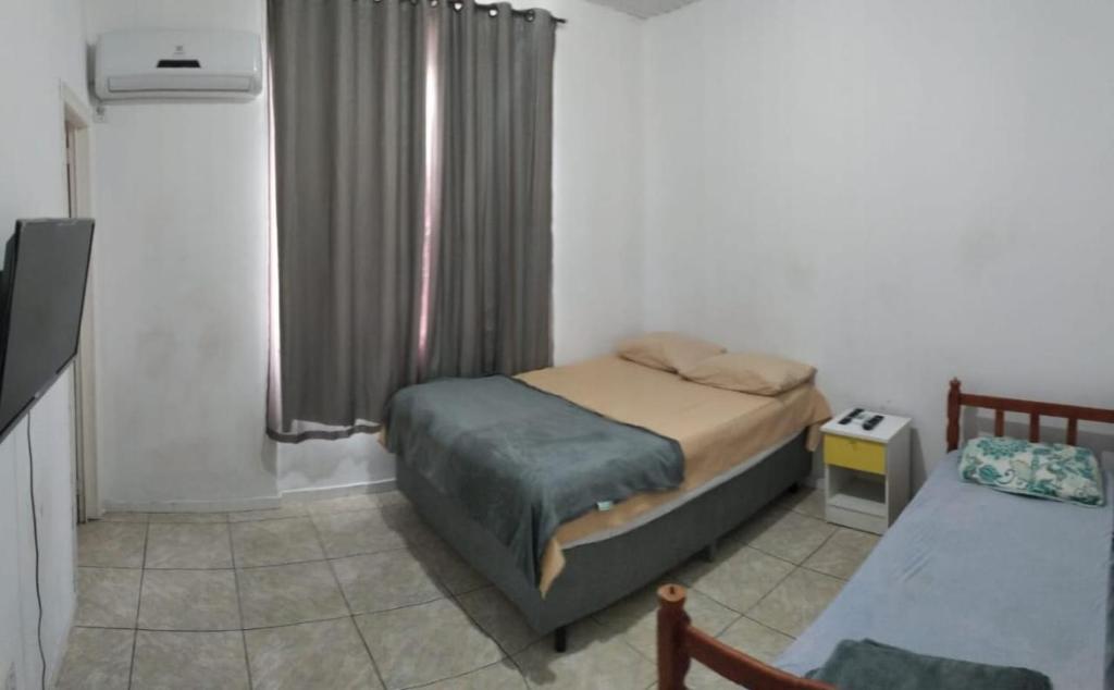 a small bedroom with two beds and a window at Pousada Central - Prox da Rodoviaria, Shoping Total, Hosp Santa Casa e Presidente Vargas in Porto Alegre