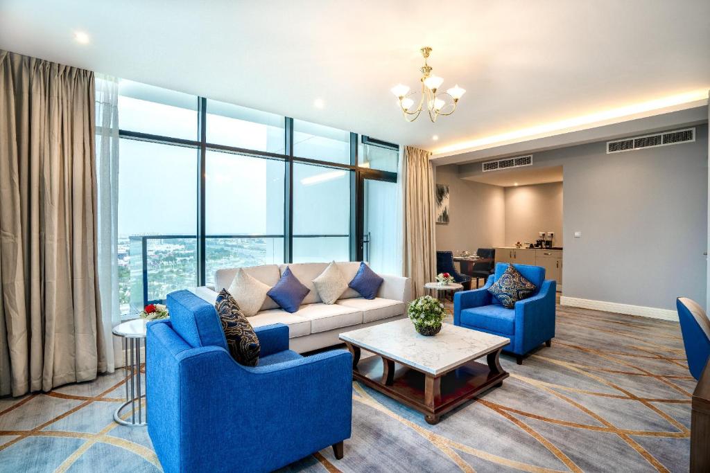 a living room with blue chairs and a couch at فندق شراعوه الملكي - Luxury in Doha