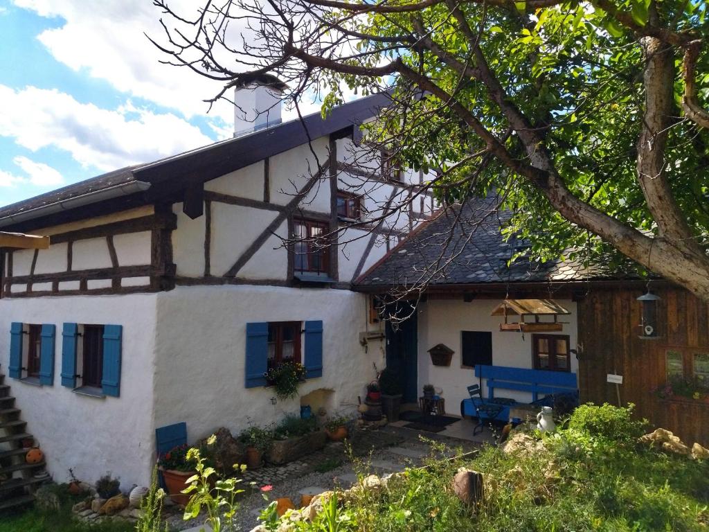 a white house with blue windows and a tree at Ferienwohnung Alte Schmiede in Beilngries