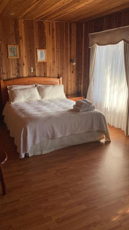 um quarto com uma cama branca e uma janela em Fragaria Hotel Gastrobar em Purén