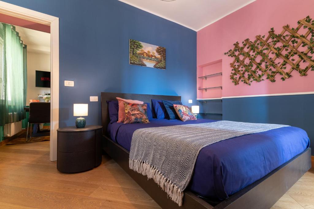 1 dormitorio con 1 cama con paredes azules y rosas en Jesi Centro Teatro Pergolesi, en Iesi