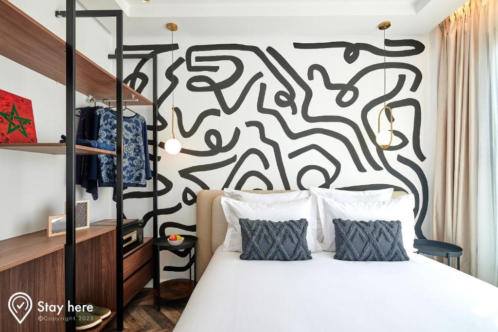a bedroom with a bed with a black and white patterned wall at Stayhere Rabat - Agdal 4 - Hotel in Rabat