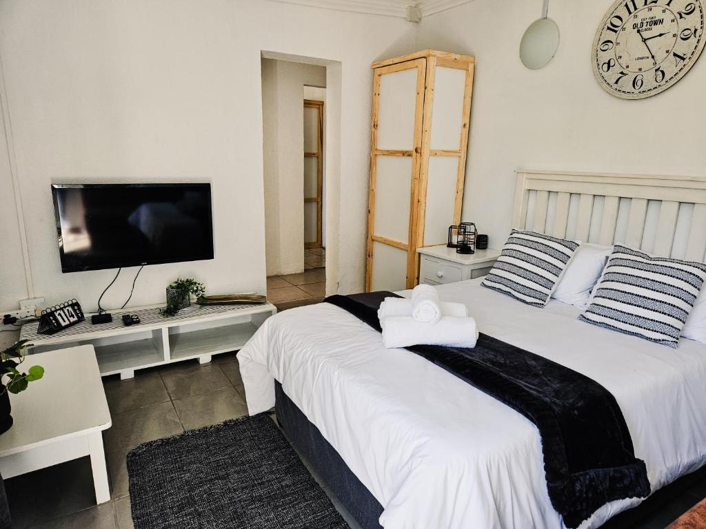 a bedroom with a large bed with a clock on the wall at Apartment on 4th Avenue in East London