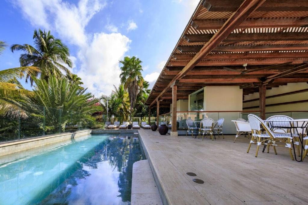 ein Haus mit einem Pool und einer Terrasse mit Stühlen in der Unterkunft Eurostars Marqués de Villalta in Cartagena de Indias