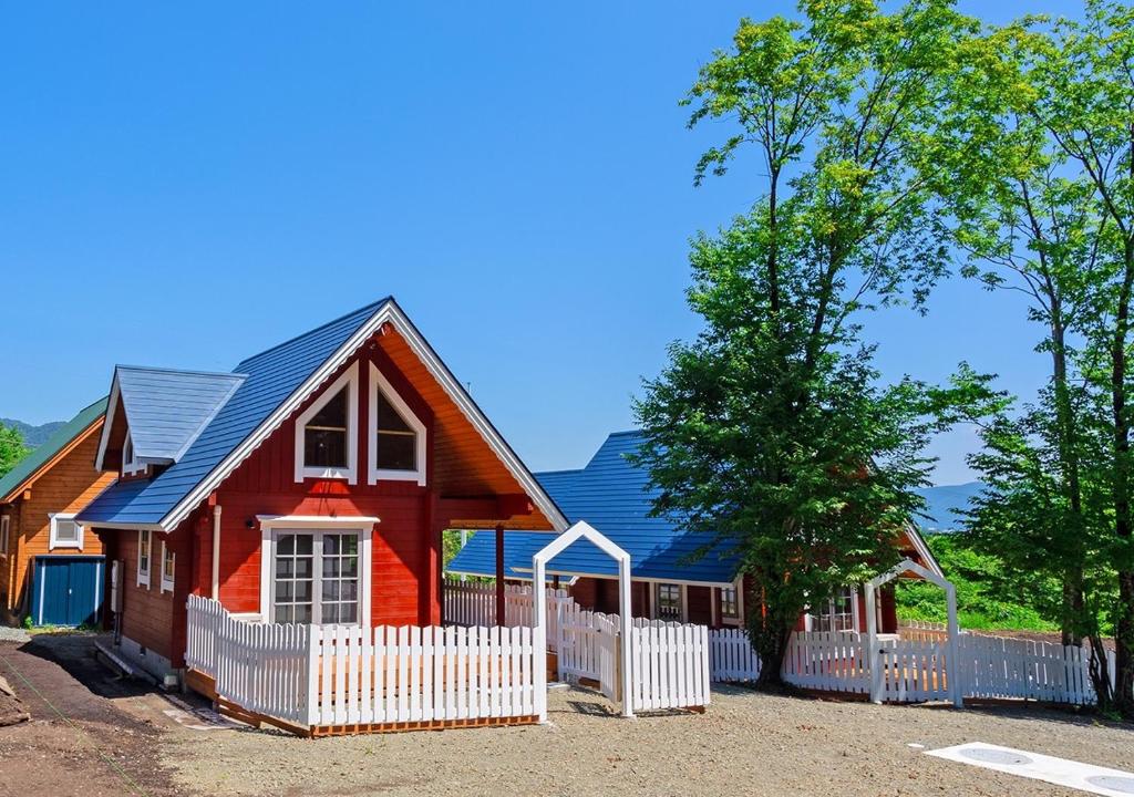 a red house with a white fence in front of it at Biwako Hills Resort - Vacation STAY 94635v in Takashima