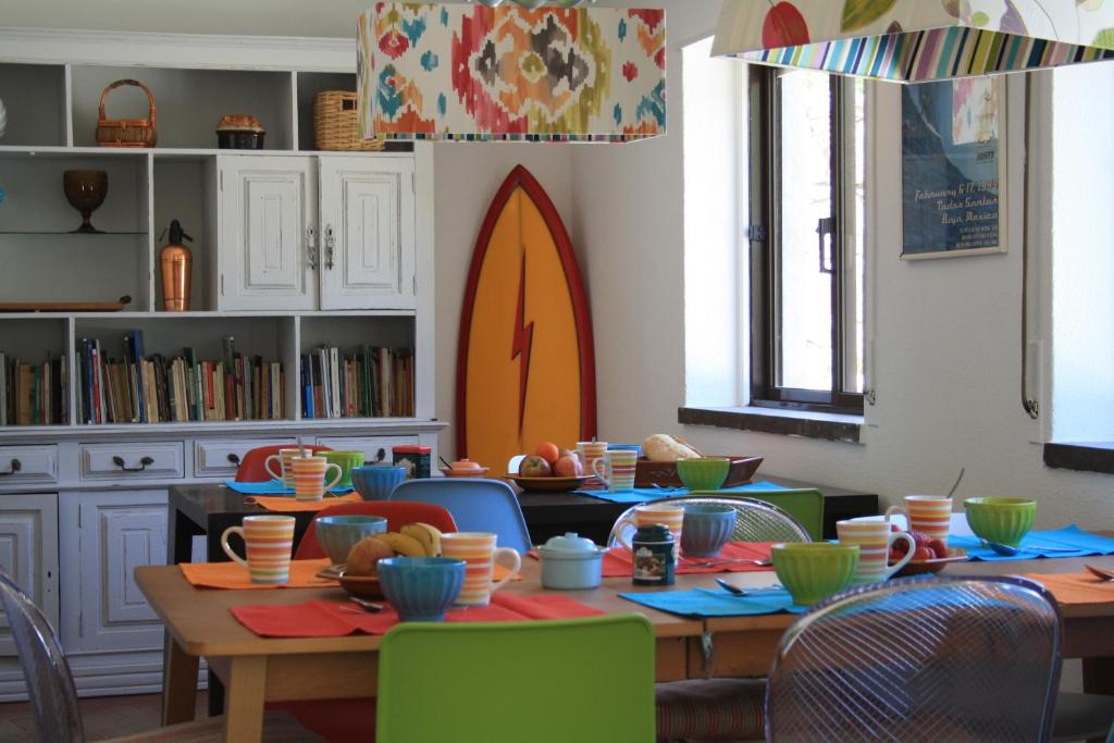 comedor con mesa y sillas con tazones en Moby Dick Lodge, en Malveira da Serra