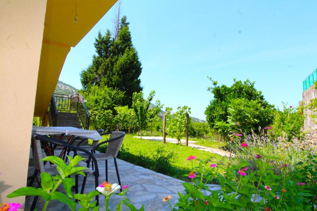 a patio with a table and chairs in a garden at Apartments Stevan in Bar