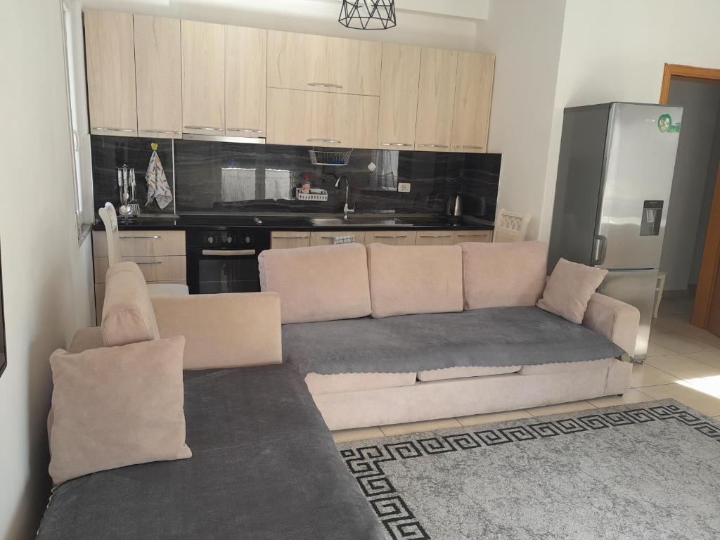 a living room with a couch and a kitchen at COMFY CITY CENTER APARTMENT in Shkodër